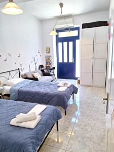 a bedroom with three beds and a blue door at Ariadne Studio in Kyparissia