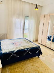 a bedroom with a bed and a large window at Belle villa avec jardin Ennacer in Ariana