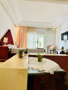 a living room with a table and a bed at Belle villa avec jardin Ennacer in Ariana +3 photos