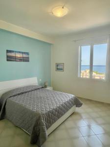 a bedroom with a bed and a view of the ocean at Le finestre sul mare in Santa Flavia