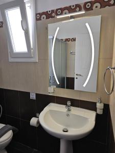 a bathroom with a sink and a mirror at Alice Maisonette & Studios in Adamantas
