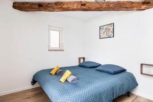 a bedroom with a blue bed with blue pillows at Nationale 202 CahorsCityStay in Cahors