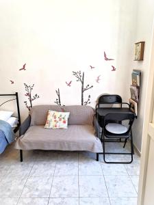 a living room with a couch and birds on the wall at Ariadne Studio in Kyparissia