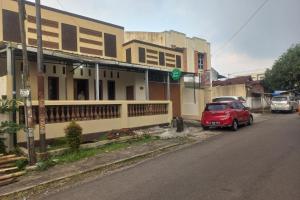 a red car parked in front of a building at SPOT ON 93917 Homestay Adreena Syariah in Purwokerto