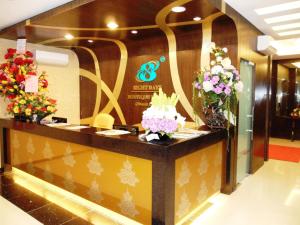 a hotel lobby with a reception counter with flowers at Eight Days Boutique Hotel - Mount Austin in Johor Bahru