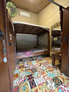 um quarto com piso colorido em azulejo e beliches em Bedhot Homestay em Yogyakarta