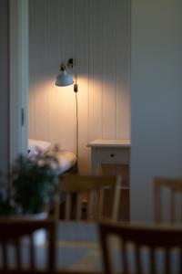 Cette chambre dispose d'une table et d'une lampe sur un mur. dans l'établissement Breviken Golf & Hotell, à Brevik