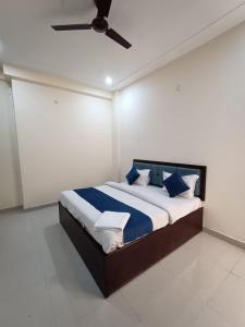 a bedroom with a bed with blue and white pillows at Hotel JP Inn in Lucknow