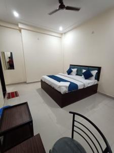 a bedroom with a bed with blue and white pillows at Hotel JP Inn in Lucknow