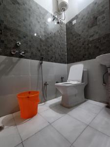 La salle de bains est pourvue de toilettes, d'une douche et d'un lavabo. dans l'établissement Hotel JP Inn, à Lucknow