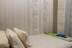 a bed with white sheets and pillows in a bedroom at OYO 93918 Wisma Tulip 