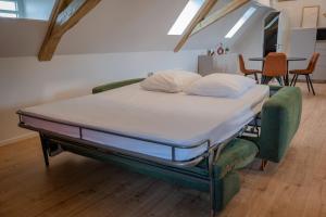 a bed in a room with two pillows on it at Le 1552 - Gîte de charme - Parking Gratuit in Bergheim +34 photos