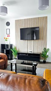 un salon avec une télévision à écran plat sur un mur dans l'établissement Deluxe 2-bed apartment with free parking, netflix & fast WiFi, à Farnworth