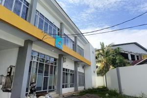 ein weißes Gebäude mit einem gelben und weißen in der Unterkunft OYO 93929 Erbee Inn in Makassar