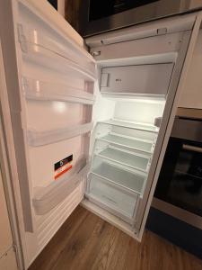- un réfrigérateur vide avec une porte ouverte dans la cuisine dans l'établissement Appartement 6 personnes - lit King size - balnéo - wifi, au Puy-en-Velay