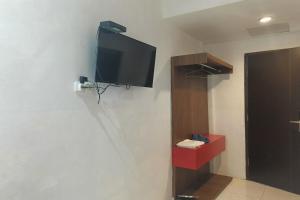 einen Flachbild-TV an der Wand eines Zimmers in der Unterkunft OYO 93929 Erbee Inn in Makassar