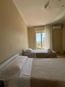 a hotel room with two beds and a window at Casa Zelia in Ercolano