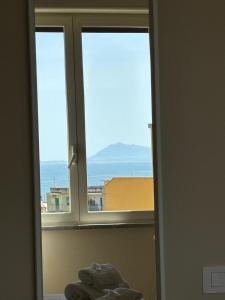 a window in a room with a view of the ocean at Casa Zelia in Ercolano +13 photos