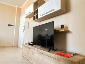 uma grande televisão de ecrã plano em cima de um centro de entretenimento em madeira em Holiday Location 585 em Durrës