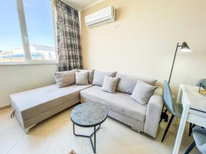 ein Wohnzimmer mit einem Sofa und einem Tisch in der Unterkunft Holiday Location 585 in Durrës