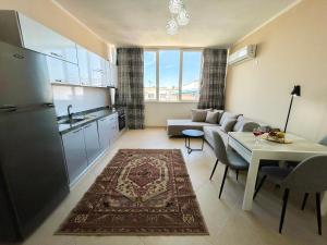 kuchnia i salon z kanapą i stołem w obiekcie Holiday Location 585 w Durrës