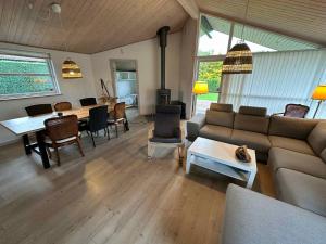 a living room with a couch and a table at Luxury House, Spa-sauna, Pool, Carcharger, River in Fårvang