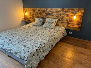 a bedroom with a bed with a wooden headboard at Appartement 6 personnes - lit King size - balnéo - wifi in Le Puy-en-Velay