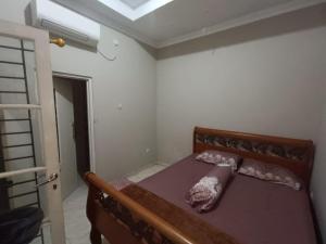 ein kleines Schlafzimmer mit einem Bett in einem Zimmer in der Unterkunft OYO 93932 Paviliun Dr Edison in Bogor