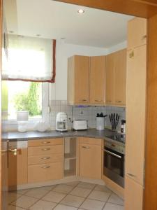 a kitchen with wooden cabinets and a window at FeWo Elisabeth am Harztor in Osterode +26 photos