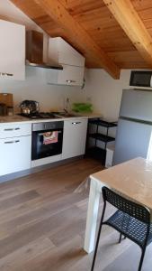 a kitchen with white cabinets and a table and a stove at Lanovella in Cava deʼ Tirreni