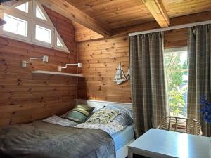 a bedroom with a bed in a log cabin at Ustka- domek nad morzem Marta in Ustka