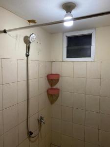 uma casa de banho com um chuveiro, um WC e uma janela. em OYO 93933 King's Room em Bekasi