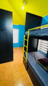 a room with two bunk beds and a yellow ceiling at Night Space hostel in Kalpetta