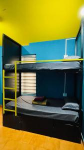 two bunk beds with yellow rails in a room at Night Space hostel in Kalpetta