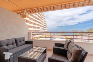 Un balcón con sofás y vistas al océano. en Zafiro, en Calpe