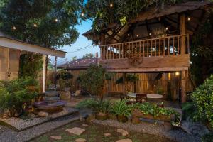 a garden with a wooden building with a deck at Villa Raya w Outdoor Cinema, Bonfire, Treehouse & Parking in Vigan