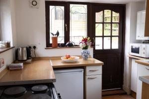 a kitchen with a vase of flowers on a counter at Deer House in Machynlleth