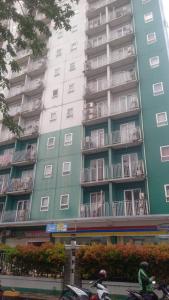 un grand immeuble d'appartements avec balcon et deux personnes à vélo dans l'établissement OYO 93933 King's Room, à Bekasi