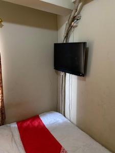 - une chambre avec une télévision murale à écran plat dans l'établissement OYO 93933 King's Room, à Bekasi