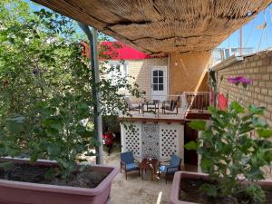 un patio con mesa, sillas y algunas plantas en Usman Heritage Hotel, en Bukhara