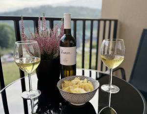 a table with two glasses of wine and a bowl of pasta at Apartmány Čerňák - Horňák - 4-6 osob, balkon, dvě parkovací místa in Černý Dŭl