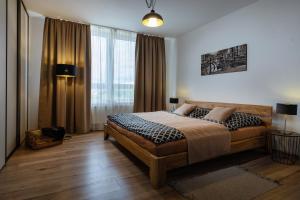 une chambre avec un lit et une grande fenêtre dans l'établissement A-PARTMAN SK - Main Square - Private Parking - Mountain View - Top Floor - 82 m2, à Poprad
