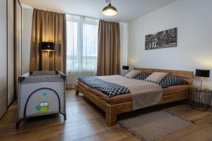 une chambre avec un grand lit et une grande fenêtre dans l'établissement A-PARTMAN SK - Main Square - Private Parking - Mountain View - Top Floor - 82 m2, à Poprad