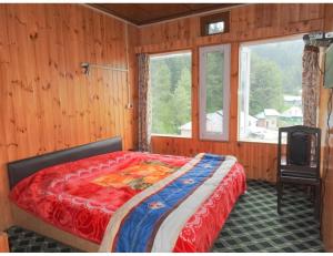 een slaapkamer met een bed en een televisie. bij Hotel Yemberzal & Restaurant, Jammu and Kashmir in Gulmarg
