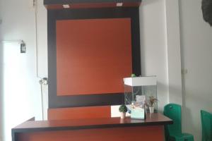 an orange and black wall in a room with a desk at Hotel O Tasya Homestay in Porsea +22 photos