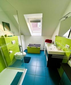 baño verde con lavabo y aseo en Apartment Kirschti en Salzwedel