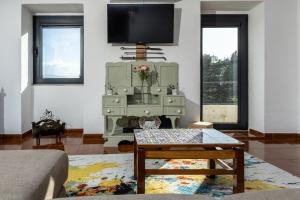 a living room with a tv and a table at Casa dos Bardos in Alvações do Corgo