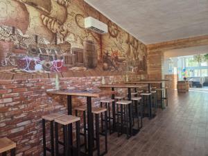 a restaurant with a brick wall with bar stools at OW Gromada Pod Bukami in Międzyzdroje