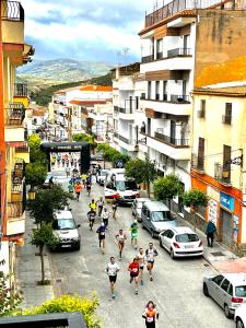 a group of people running down a city street at El Montoro in Cádiar