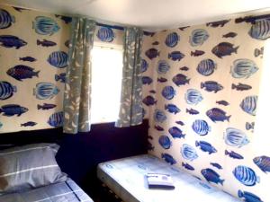 een slaapkamer met een muur met vispatronen bij Clareira in Quiaios